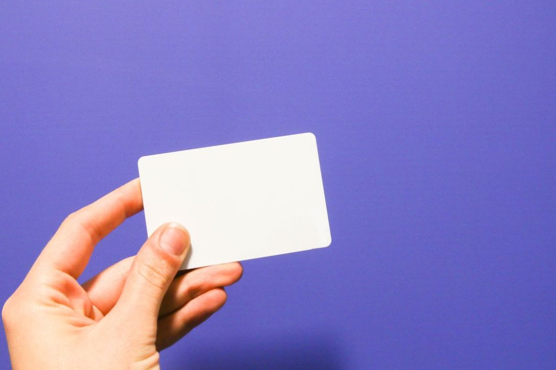 Hand holding a blank white card