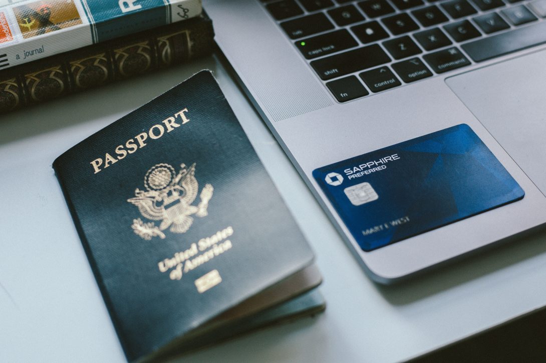 A passport and a Chase Sapphire Preferred card on the laptop