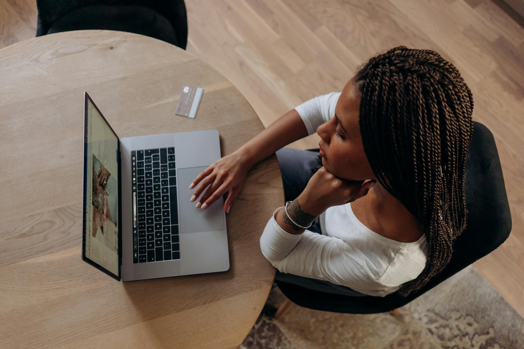 A woman sitting at a table, using a laptop