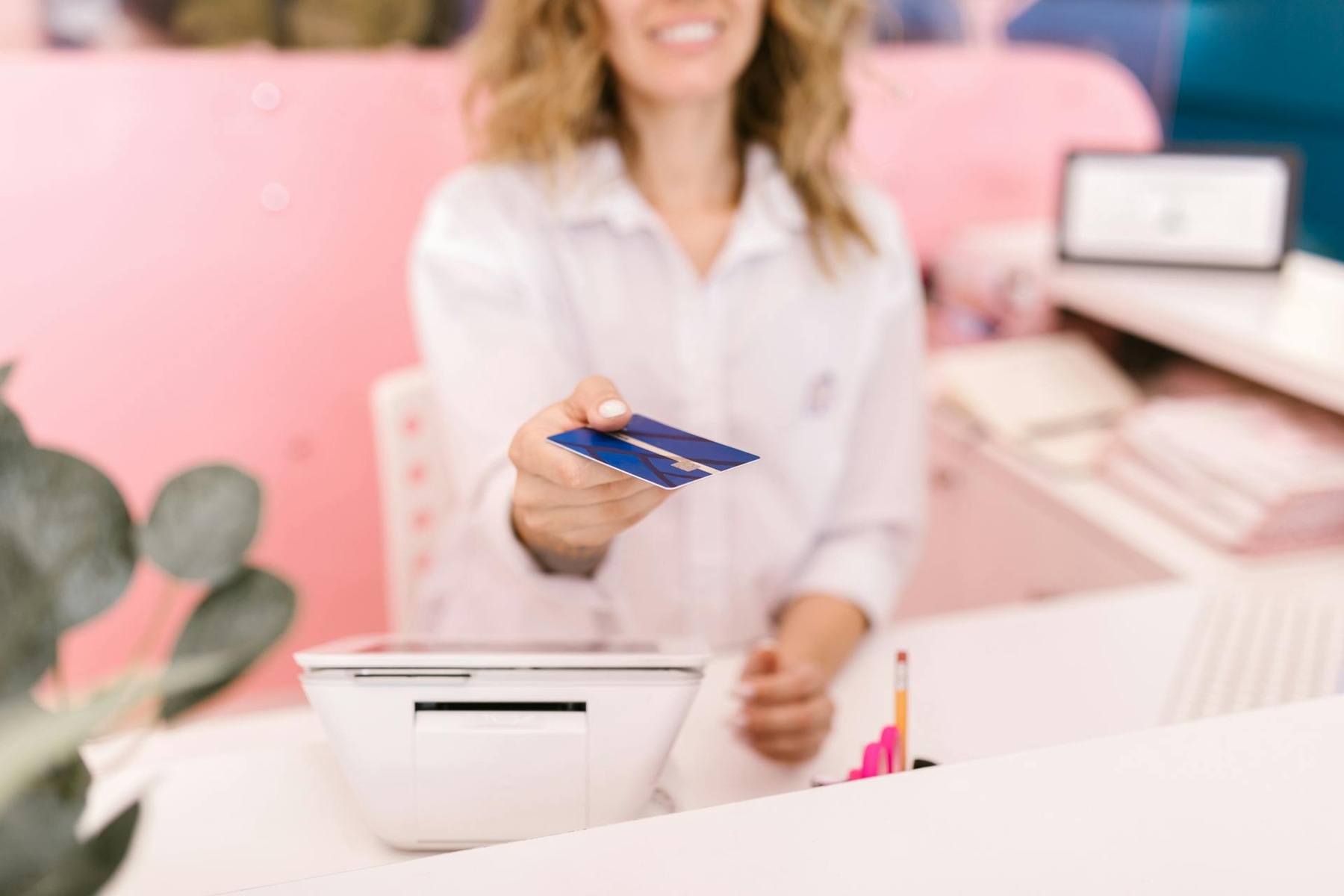 Lady holding credit card while seated at desk