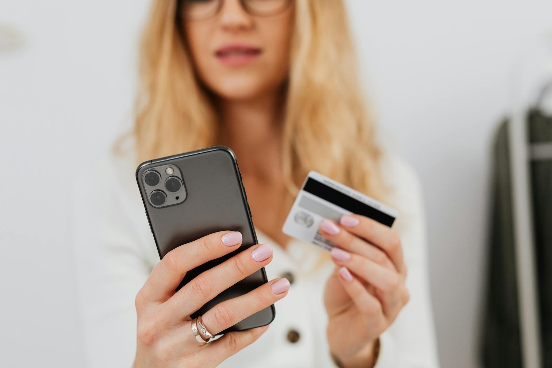 A woman holding a credit card and a smartphone, ready for online shopping and making secure transactions