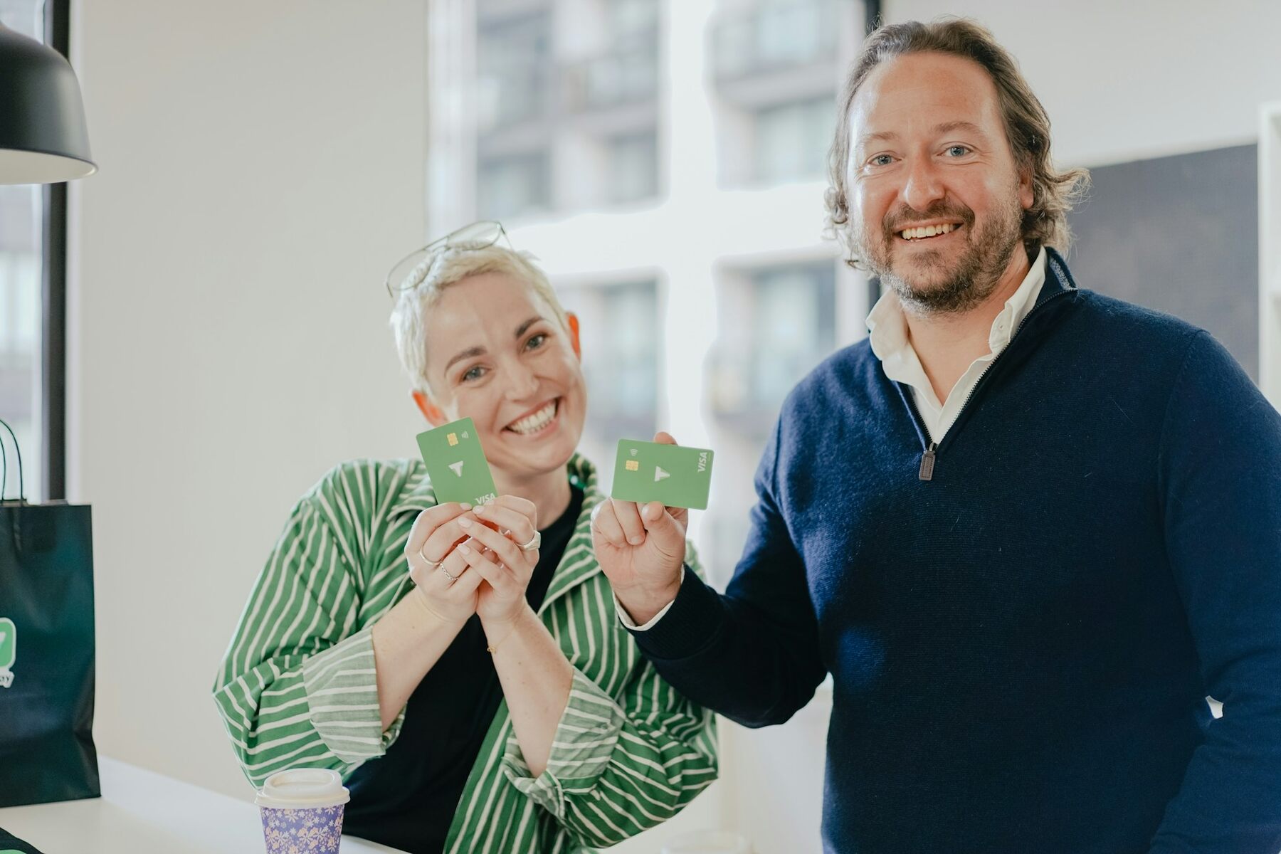 A man and a woman smiling while holding a credit card
