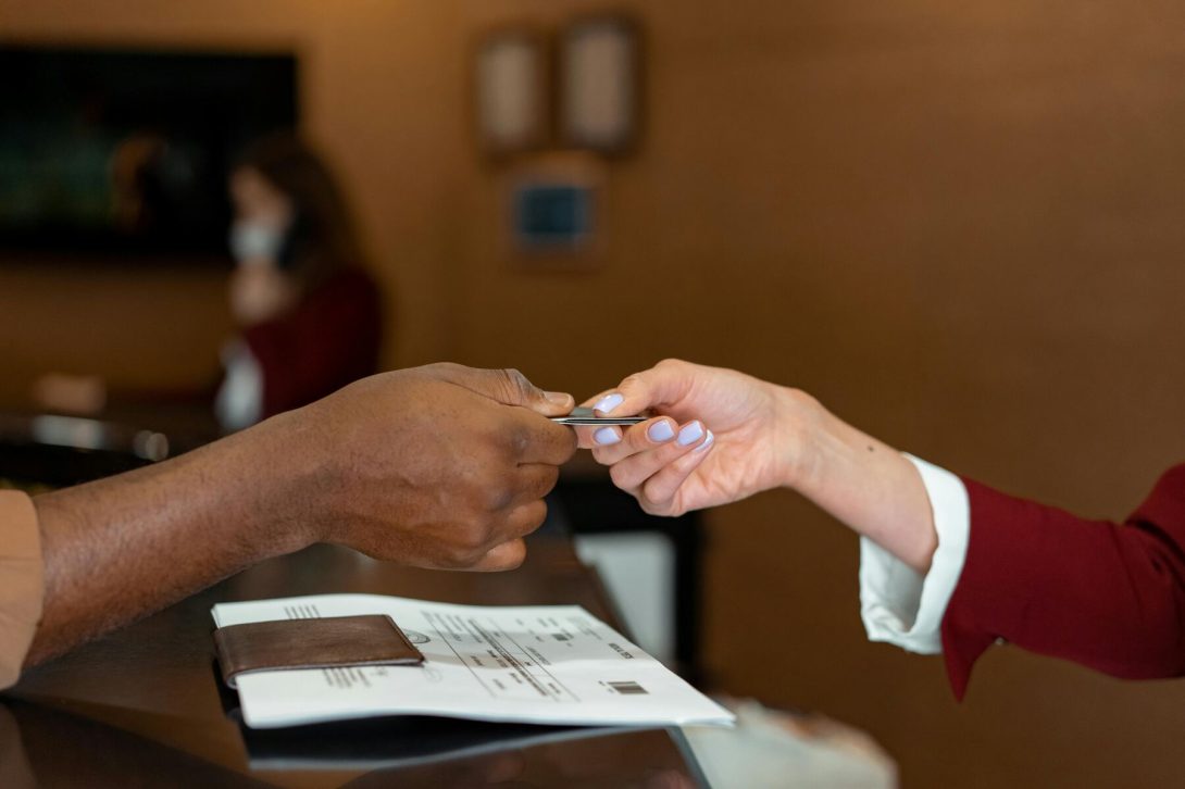 A person giving the credit card to the other woman