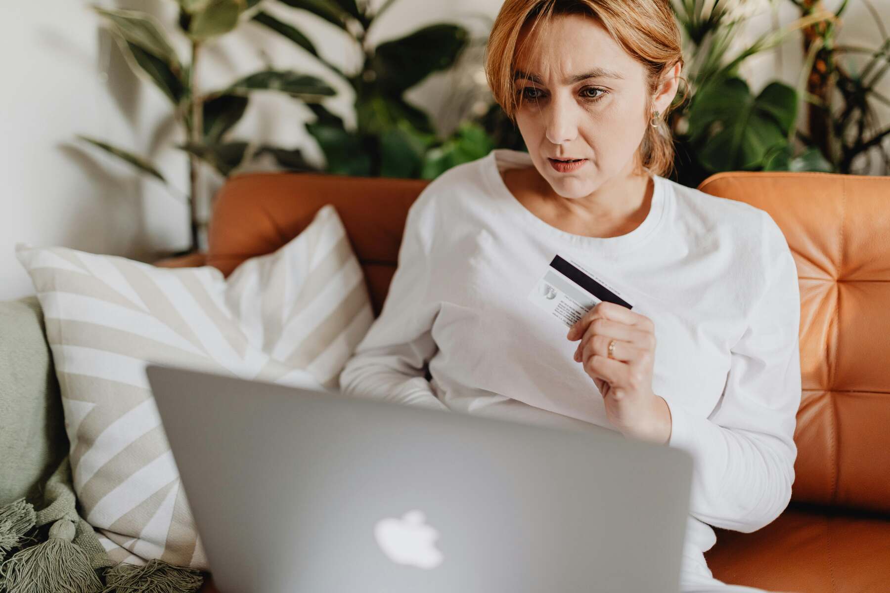 A woman using her laptop while holding her credit card