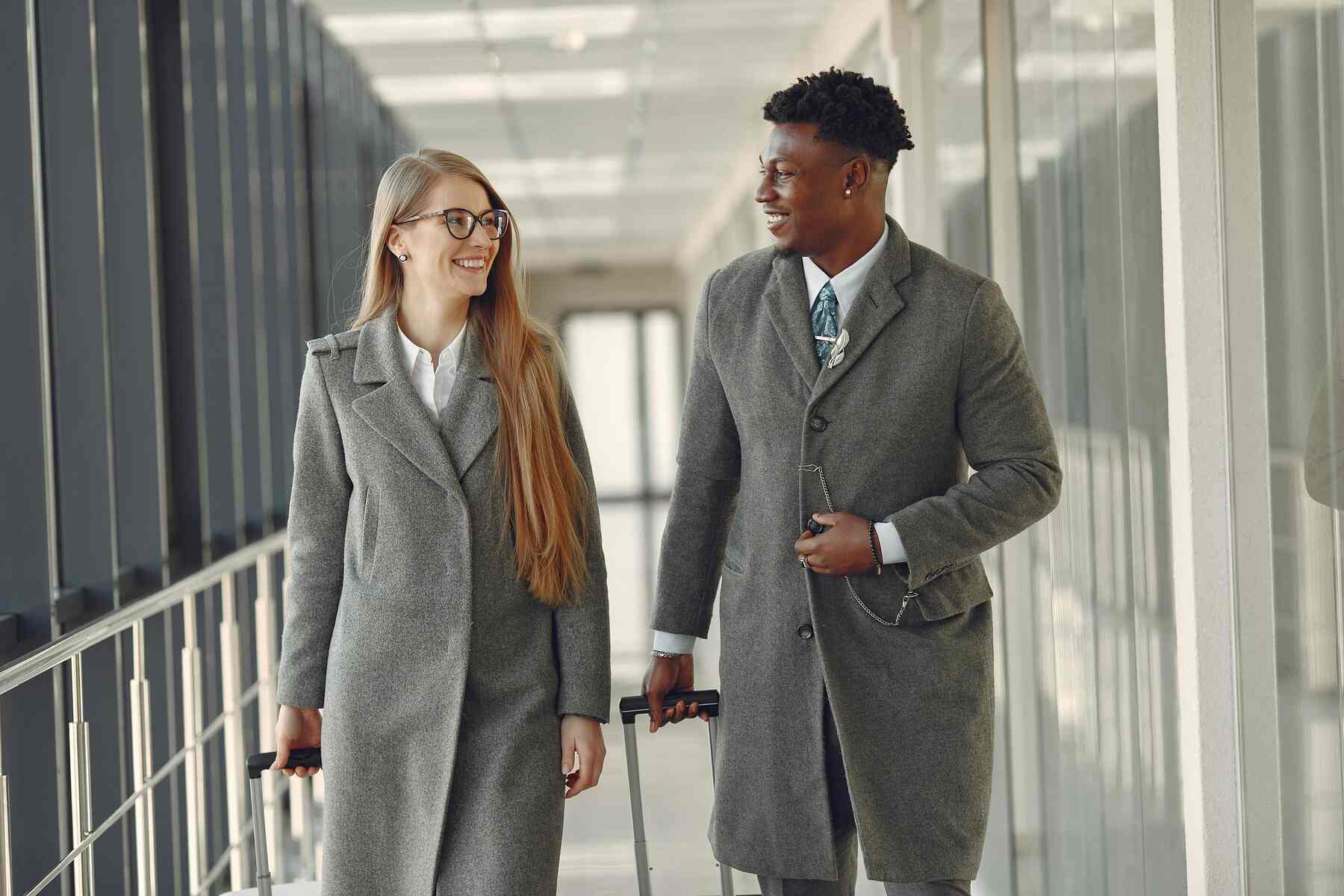 A man and a woman walking on the airport for a business trip